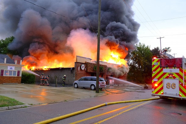 Flames and dark smoke rise from The Party Shop store as it became fully engulfed in fire.